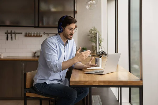 Man wear headphones communicating through videoconferencing use laptop — Stock Photo, Image