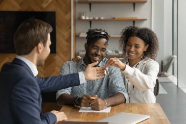 African couple getting keys to first own house from realtor