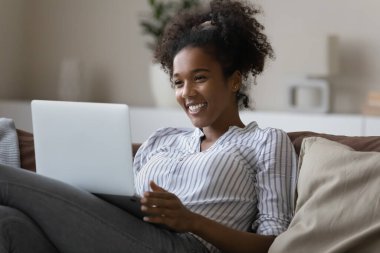Smiling African American woman talk on video call on laptop