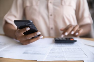 Close up of ethnic woman manage finances on smartphone