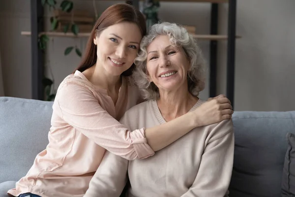 Portrait of grownup daughter and senior mom relax at home — Fotografia de Stock