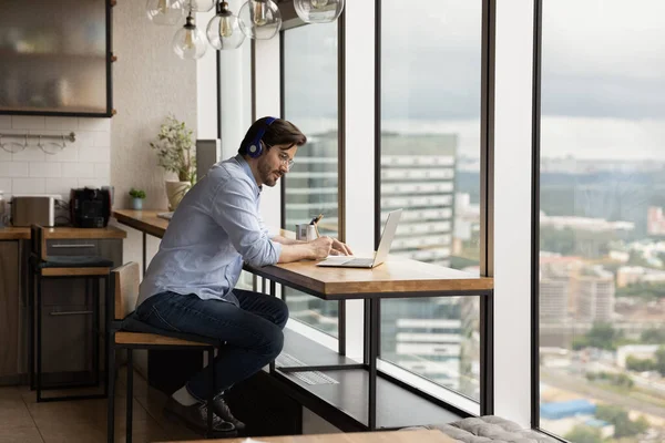 Man studying wear wireless headphones listen audio course making notes — Foto Stock