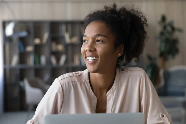 Smiling African American woman work on laptop dreaming —  Fotos de Stock