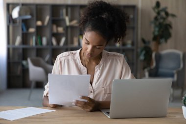 Young ethnic woman work on computer study paperwork