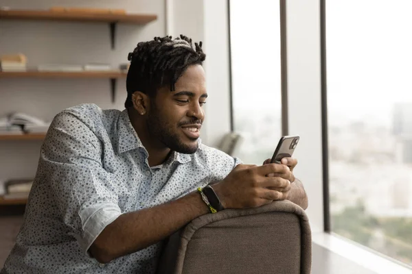 African guy take break at modern office using smartphone — Fotografia de Stock