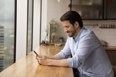 Guy sit indoor holding smartphone communicate in social networks