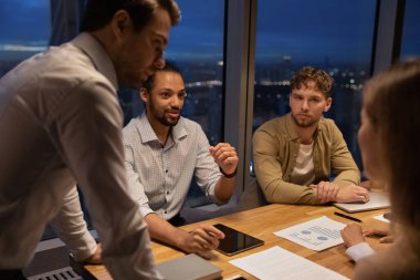 Group of multiethnic colleagues work until late in modern office