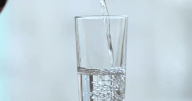 Pure fresh water poured into glass, close up background