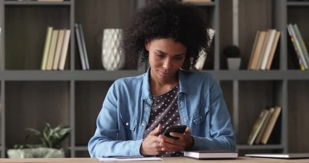 Happy african american woman using cellphone applications. — Stockvideo