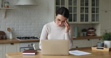 Stressed young business woman taking off glasses, suffering from eyestrain.