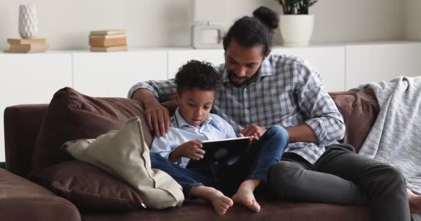 Happy bonding mixed race family using digital tablet. — стоковое видео