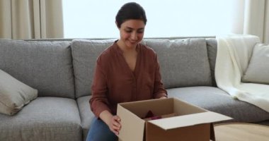 Happy Indian woman unpack parcel box with gifts
