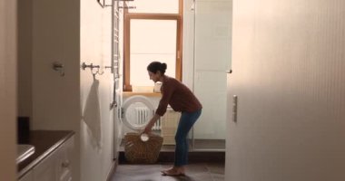 Young Indian housekeeper doing routine housework at modern home