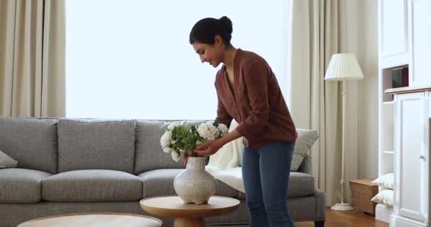 Indian woman puts in vase bunch of fresh natural roses — стокове відео