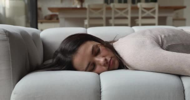 Exhausted young woman fallen asleep on comfortable sofa. — Wideo stockowe