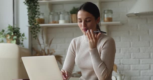 Smiling young woman recording audio message, working on computer. — Stock Video