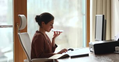 Serious Indian businesswoman holds cellphone talks to client on speakerphone