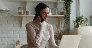 Smiling beautiful woman multitasking in modern home office.