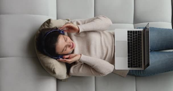 Happy millennial woman listening favorite music in wireless headphones. — Stockvideo