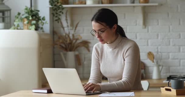 Focused serious young businesswoman in eyeglasses working distantly on computer. — ストック動画