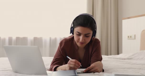 Indian woman listen webinar through headphones studying remotely at home — Video