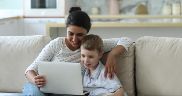 Індійська няня і маленький хлопчик дивляться мультфільми на ноутбуці. — стокове відео