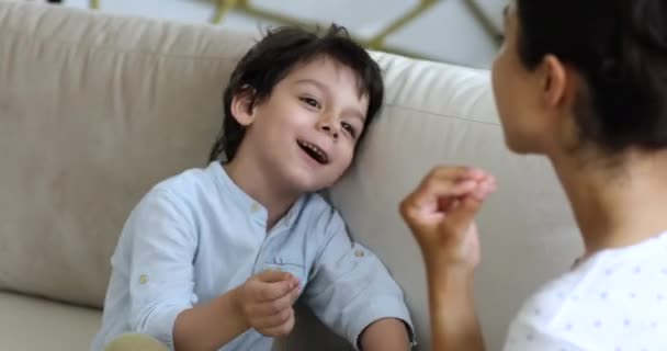 Lindo niño de raza mixta haciendo ejercicios con terapeuta del habla — Vídeo de stock