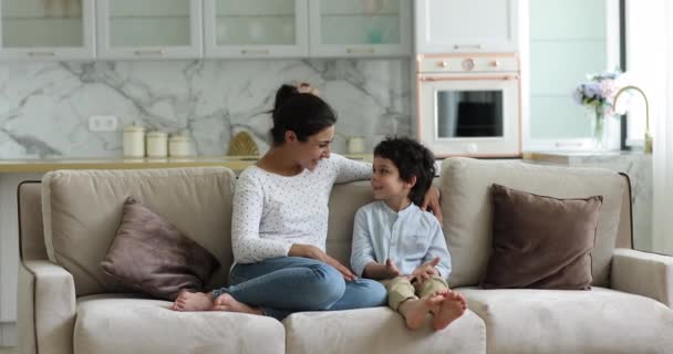 Indiana mãe e filho sentar no sofá desfrutar de uma conversa agradável — Vídeo de Stock