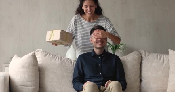 Aufmerksame junge hispanische Frau überreicht Geschenk an Ehemann. — Stockvideo