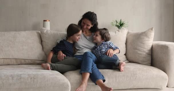 Happy loving young hispanic mother cuddling small children. — Stock Video