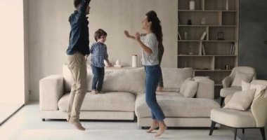 Sevinçli genç ebeveynler küçük sevimli çocuklarla eğleniyor..