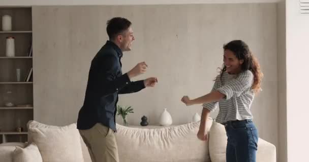 Χαρούμενο νεαρό οικογενειακό ζευγάρι που χορεύει στο σπίτι. — Αρχείο Βίντεο