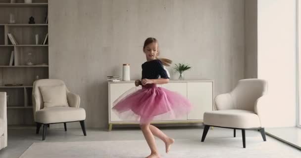 Feliz niña pequeña en falda esponjosa bailando en casa. — Vídeos de Stock