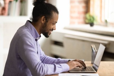 Çevrimiçi proje üzerinde çalışan Afrikalı adam mesajları, dizüstü bilgisayar kullan