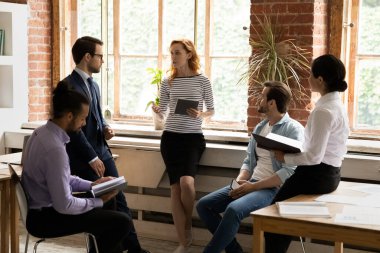 Çeşitli şirket personeli, görevdeki brifingde liderlerini dinliyor.