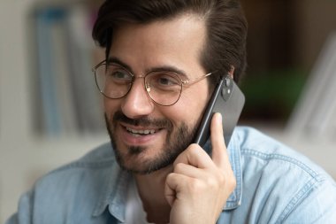 Yakışıklı milenyum ofis müdürü müşteriyle cep telefonuyla konuşuyor.