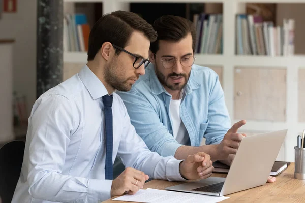 Colegas masculinos revisando y discutiendo proyecto de negocio en línea en la computadora — Foto de Stock