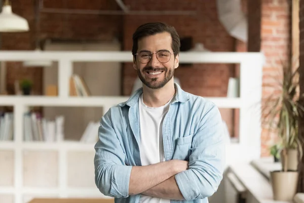 Successful businessman posing with arms crossed in office — Stock Photo, Image