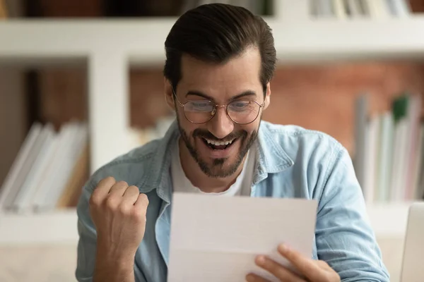 Podekscytowany człowiek czytający list pocztowy czuje się uradowany świetnymi wiadomościami — Zdjęcie stockowe
