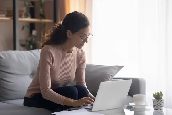 Ernsthaft fokussierte Frau trägt Brille, die am Laptop arbeitet — Stockfoto