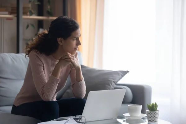 Sorglig kvinna ser åt sidan ledsen med dåliga nyheter på nätet — Stockfoto