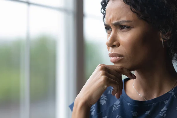 Frustrado preocupado millennial mujer afroamericana mirando por la ventana — Foto de Stock