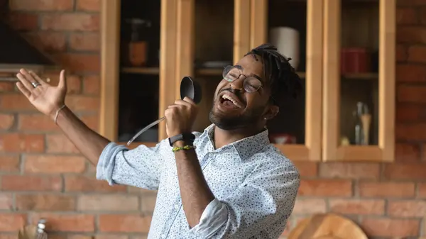 Happy excited African hipster guy having fun in kitchen — Stock Photo, Image