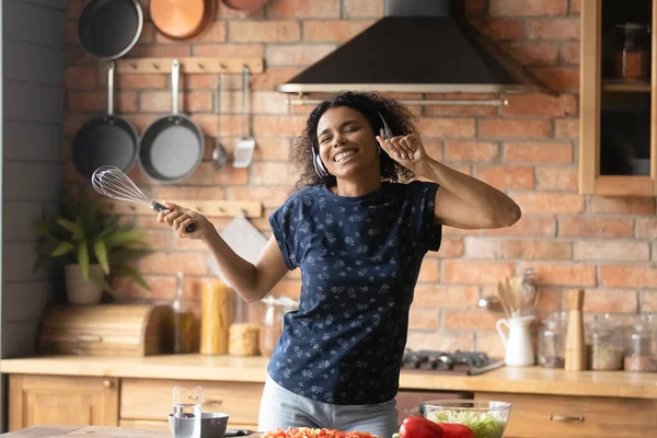 Mutlu Afrikalı Amerikalı kız mutfakta yemek pişiriyor ve eğleniyor. — Stok fotoğraf
