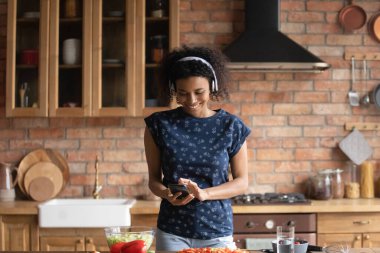 Heyecanlı genç siyah kız kulaklıklı müzik yapıyor.