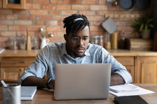 Focused African student guy studying from home, watching learning webinar — Stock Photo, Image