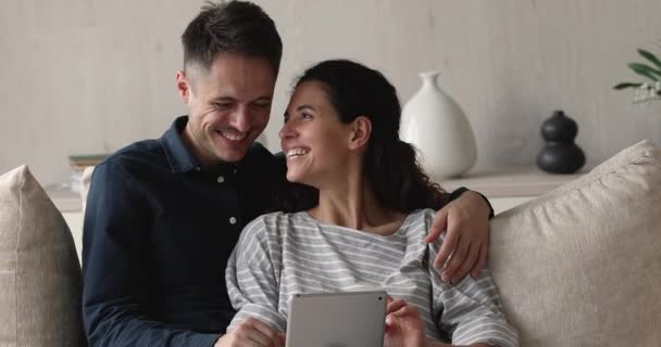 Feliz ligação jovem casal usando tablet digital em casa. — Vídeo de Stock
