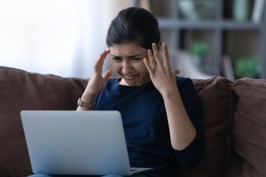 Mutsuz Hintli kadın dizüstü bilgisayarında sorun yaşıyor.