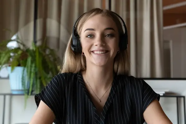 Portrait de femme souriante dans les écouteurs parler sur appel vidéo — Photo