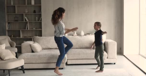 Gelukkig jong moeder en kleine dochter dansen thuis. — Stockvideo